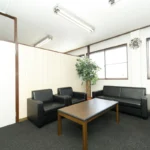 Sala de espera da Ji Consulting, com sofás e mesa de centro